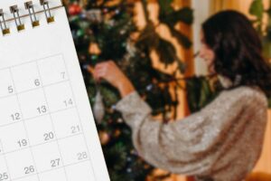 Calendario e ragazza che disfa l'albero di Natale